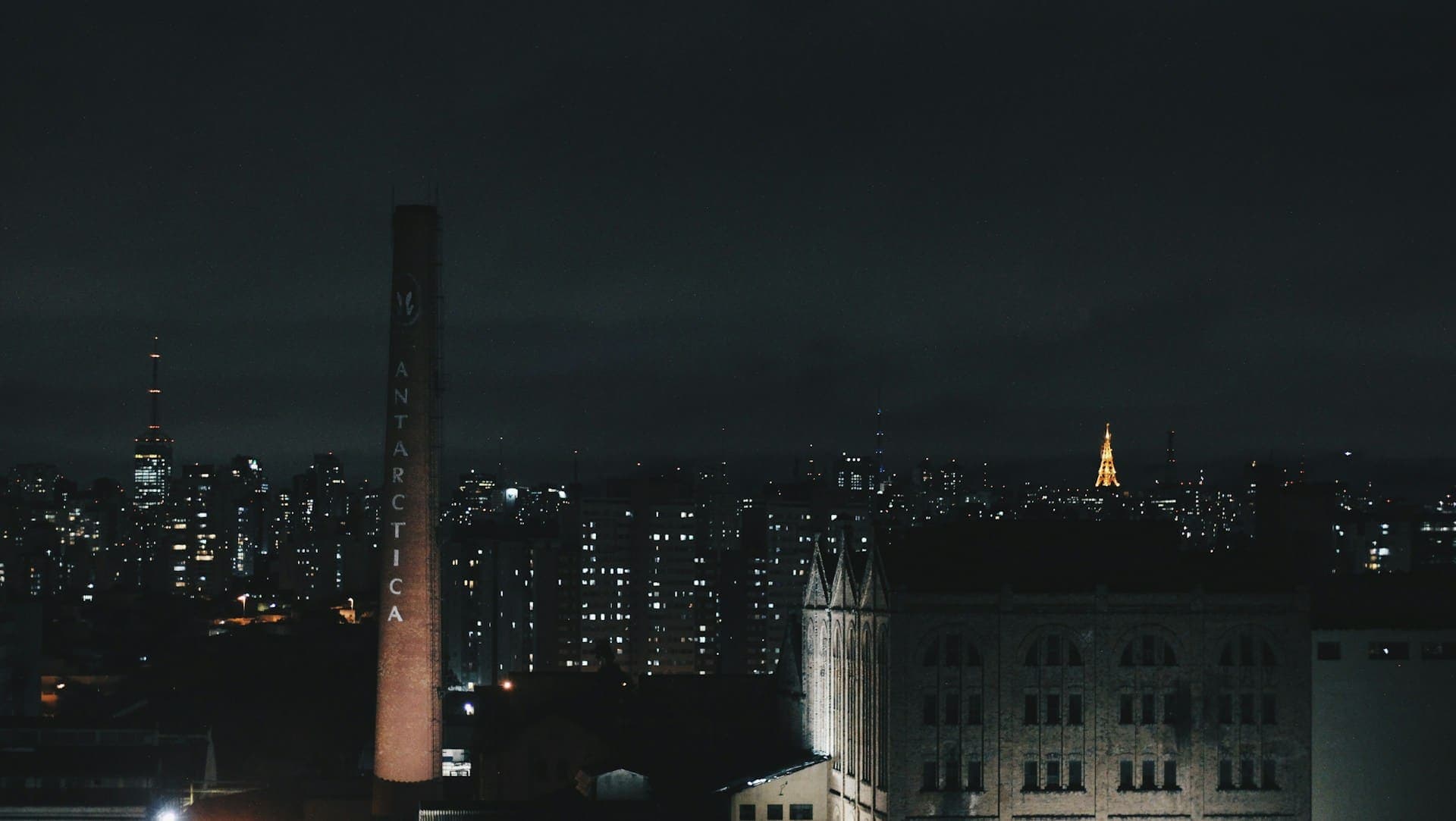Vista noturna da cidade de São Paulo com destaque para a chaminé da antiga fábrica da Antarctica Paulista, localizada na Avenida Presidente Wilson, no bairro da Mooca, em um complexo industrial desativado desde 1995.
