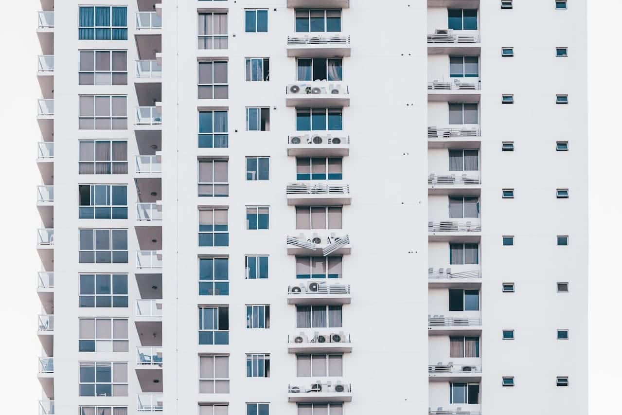 Fachada de prédio residencial com varandas e ar-condicionados, ilustrando o impacto visual das regras do condomínio sobre a organização externa.